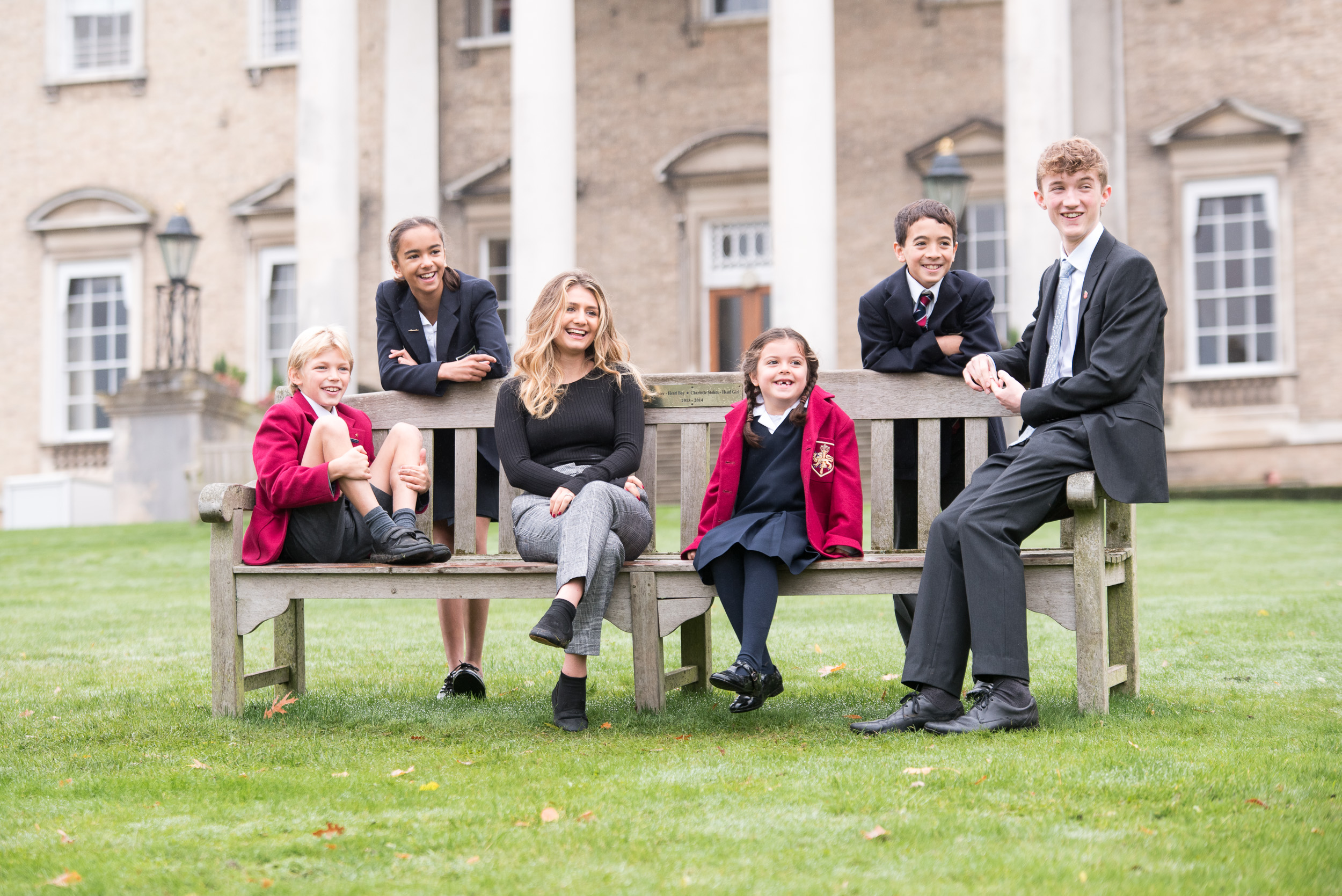Pupils pose on school bench outside mansion